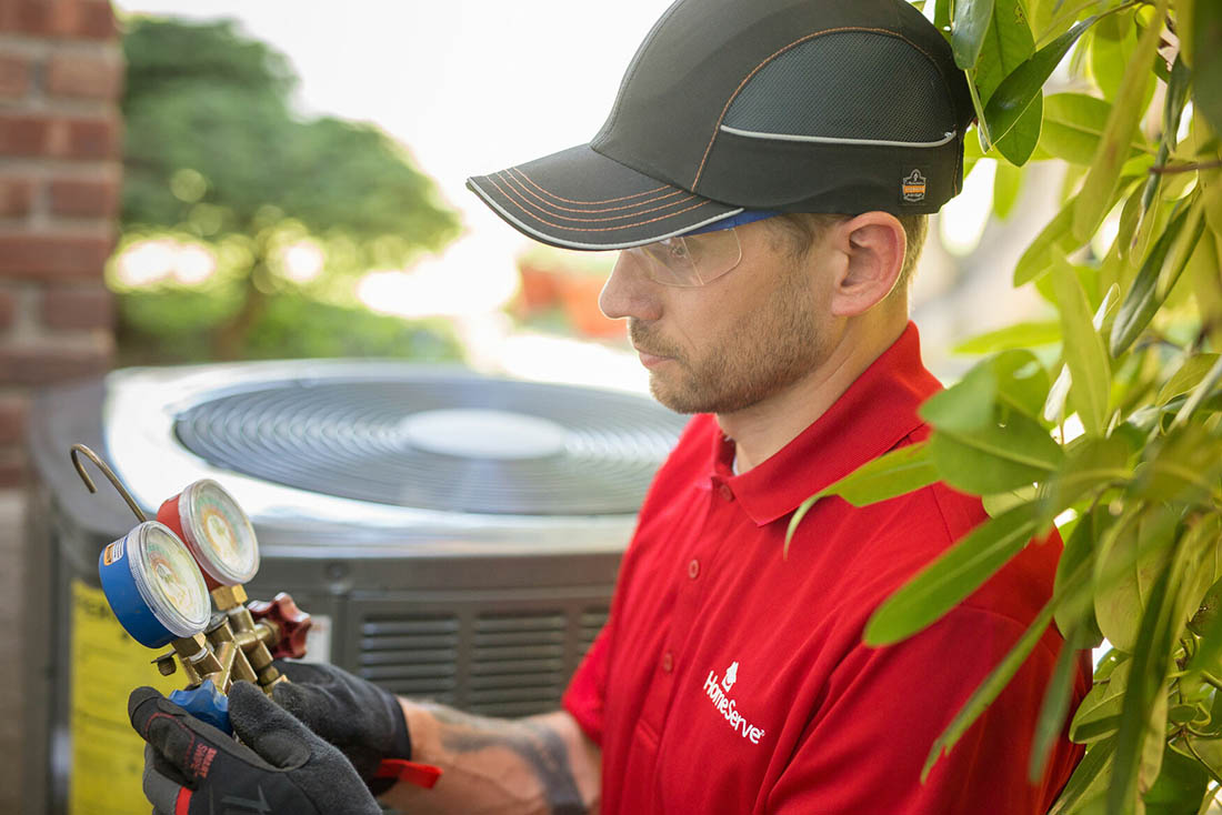 Heat Pump Installation 3 Close-up of man inspecting a tool near a heat pump unit