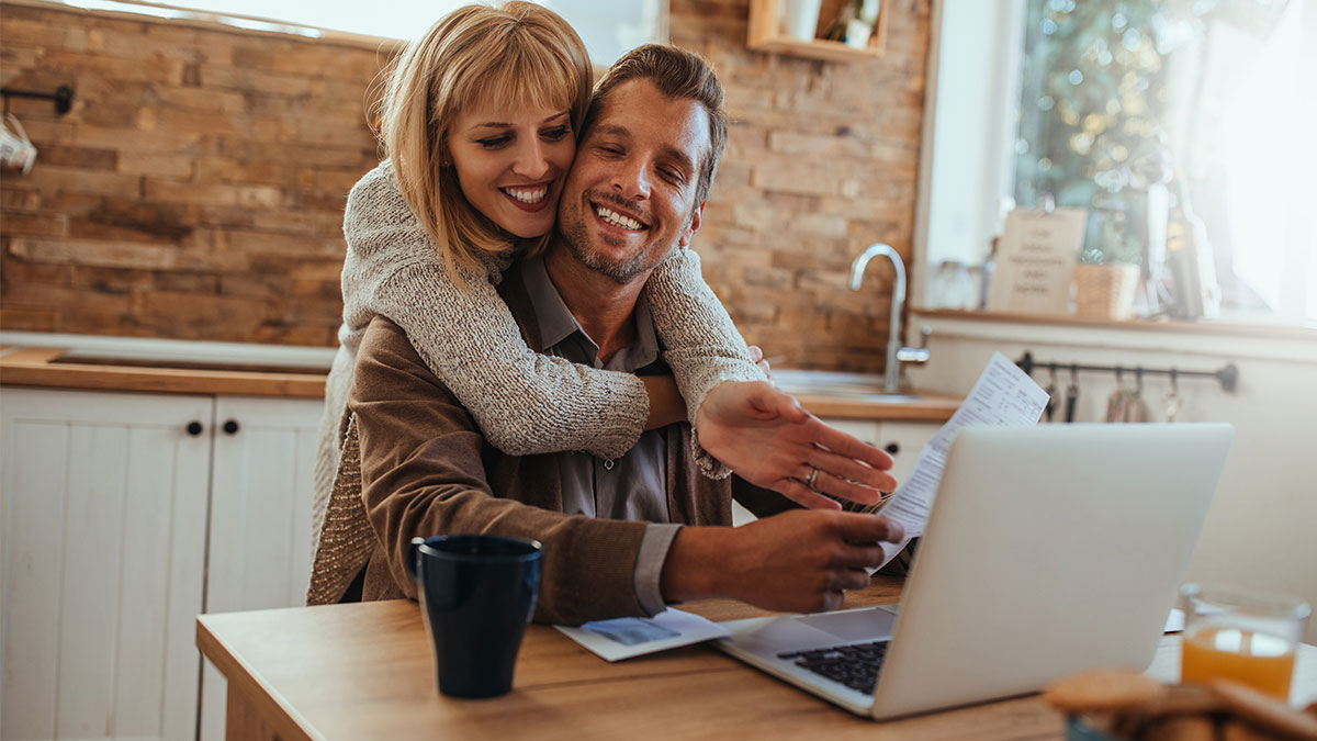 Couple looking at their laptop together and smiling